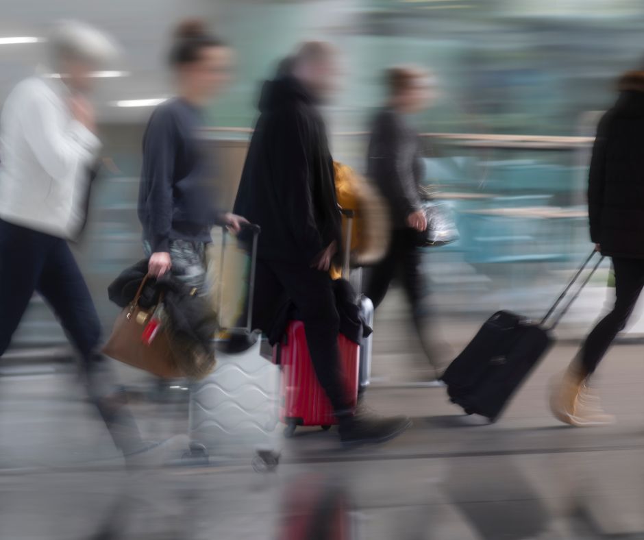 Photo is blurred but people are briskky walking with luggage for a life on the go.